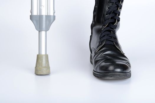 combat boot and crutch for war concept