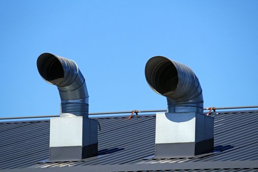 Pipes of ventilation are located on a roof of a  building