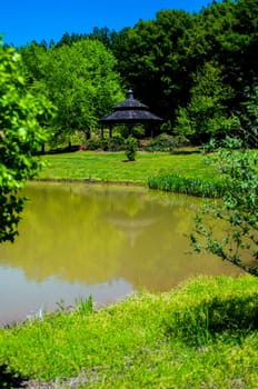 water reflects nature with gazebo in distance