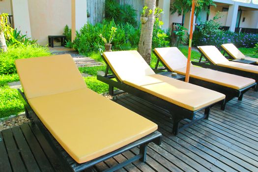 Beach chairs and umbrella side swimming pool