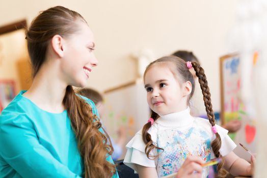 teacher talks to a schoolgirl, working at an art school