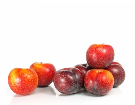 seven fresh and crunchy victoria plums on white