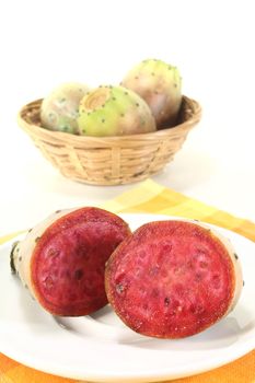 fresh succulent cactus figs on a plate in front of light background