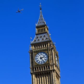 An aircraft flying high over the Houses of Parliament in London.