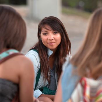 Calm young Native American teenager between two friends