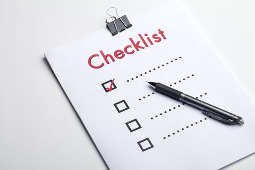 A pen on top of a checklist on a white background
