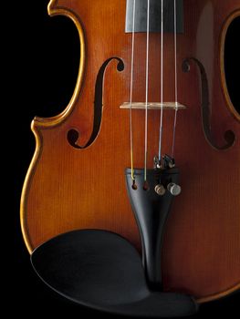 Image of a wooden violin isolated on dark background.