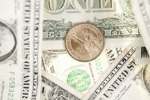 Close-up shot of one dollar coin and U.S. banknote.