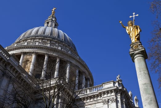 Looking up at the impressive dome of St. Paul's Cathedral and the Statue of Saint Paul in London.