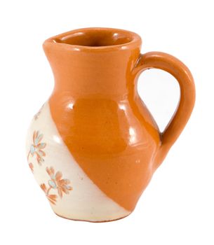old clay pitcher brown color object with handle and flower ornaments isolated on white background.