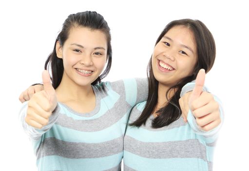 Two teenagers wearing identical clothes and doing thumbs up signs