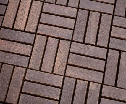 Texture of wooden flooring is dark brown, folded in a staggered