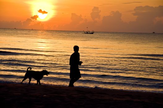 silhouette of man running on the beach with dog