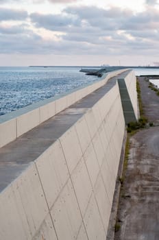 Concrete structure and sea, sunset time, dramatic sky