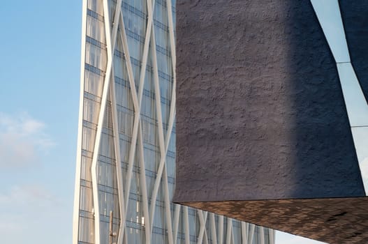 Two modern buildings over blue sky with clouds