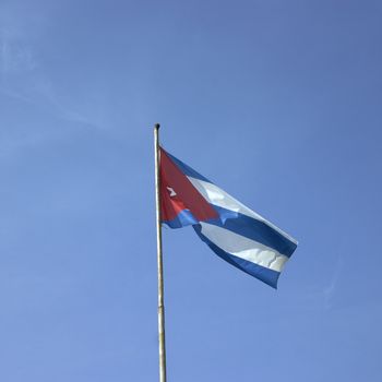 Cuban flag against blue sky
