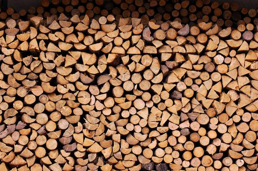 Background of dry chopped firewood logs in a pile