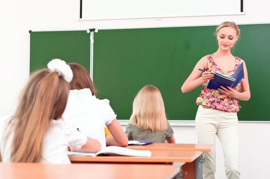 teacher stands in front of students in the class