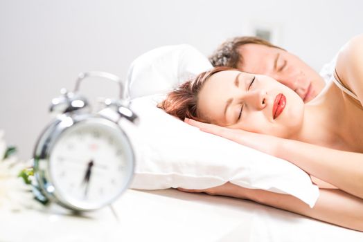 young beautiful woman sleeping on the bed with her husband