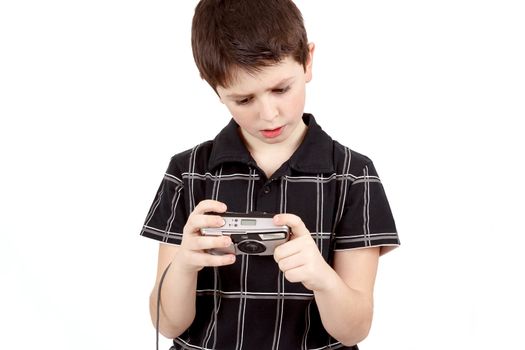 small boy checking analog camera settings on white background