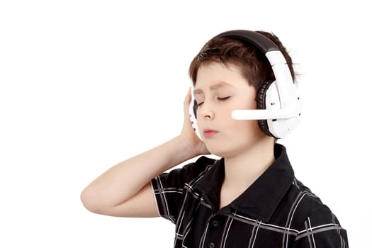 Portrait of a happy young boy listening to music on headphones against white background 