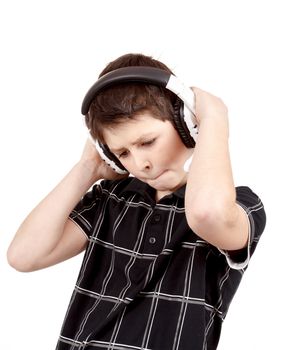 Portrait of a happy young boy listening to music on headphones against white background 