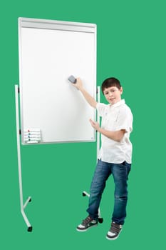 Portrait of happy little boy showing white blank board on green background