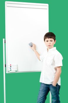 Portrait of happy little boy with white blank board on green background