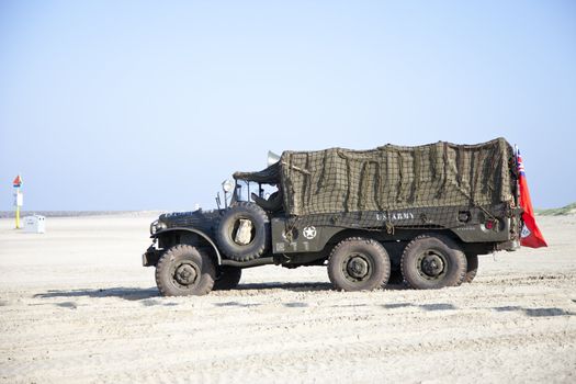 IJMUIDEN, THE NETHERLANDS-MAY 5 2013: Army trucks of organization Kelly's Heroes riding on beach on May 5,2013 in IJmuiden, The Netherlands. Simulate arrival of allies on liberation Second World War