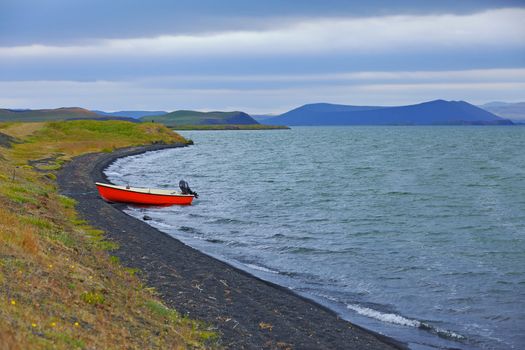 Iceland landscape with red boat on Myvatn lake in northern Iceland