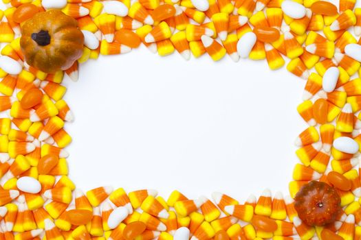 Close-up shot of arrangement of candy corns and pumpkins.