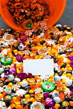 Close-up view of candies spilling out of the basket with placard on it.