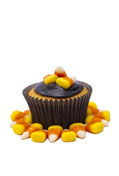 Cupcake decorated with candy corn and chocolate cream displayed on white.