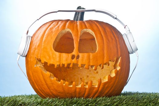 Close-up image of a carved pumpkin with white headphone