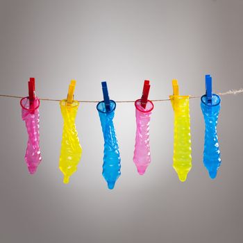 Colorful condoms with clothespins on a rope