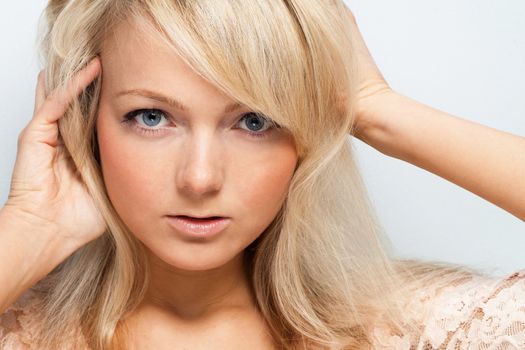 Young attractive woman posing over grey background