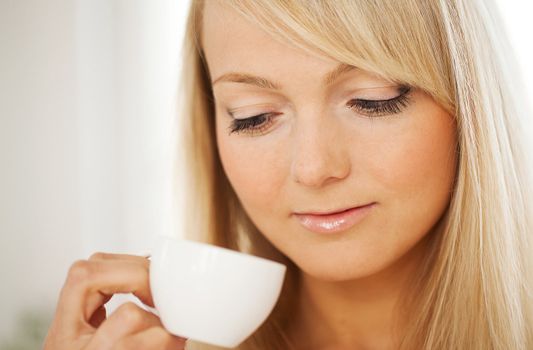 Closeup portrait of young attractive woman with cup