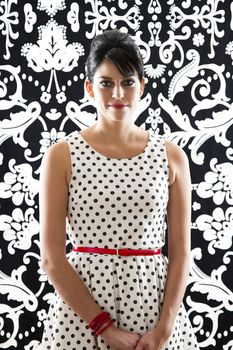 young woman in front of a black and white textured background with 60's inspired style