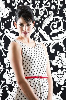 young woman in front of a black and white textured background with 60's inspired style