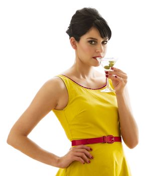 Young woman wearing a bring yellow dress having a sip of a three olive martini