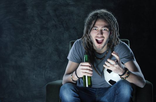Young adult man watching football on television: Goal!