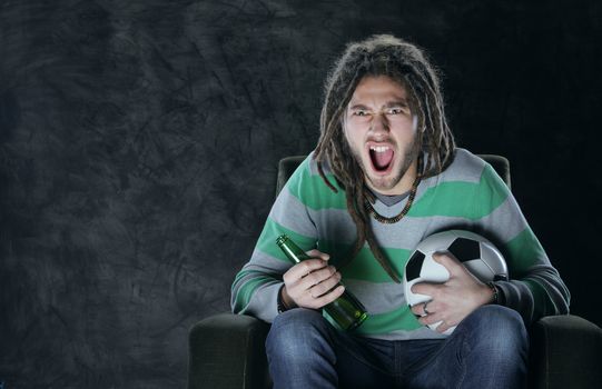 Young adult man watching football on television: Goal!