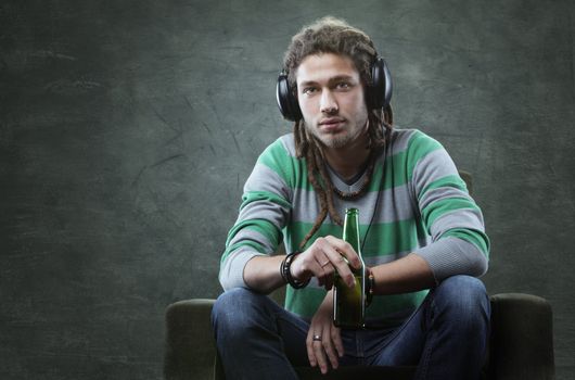 Relaxed young guy listening to music with headphones