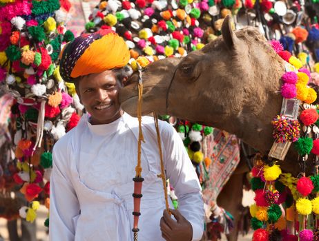 PUSHKAR, INDIA - NOVEMBER 22: Camel and his unidentified owner attends at traditional camel decoration competition at camel mela in Pushkar on November 22,2012 in Pushkar, Rajasthan, India