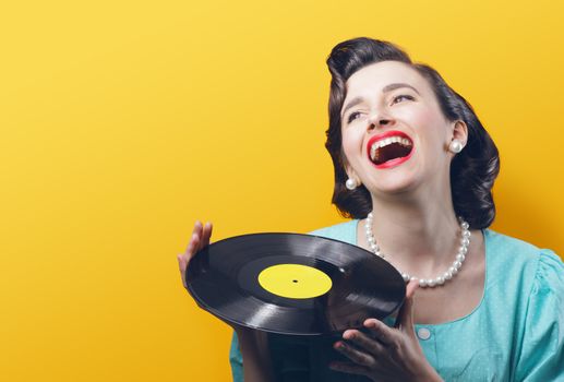 Happy woman with a vinyl record in her hands