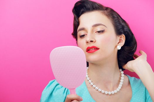 Young woman looking at her face in the mirror.
