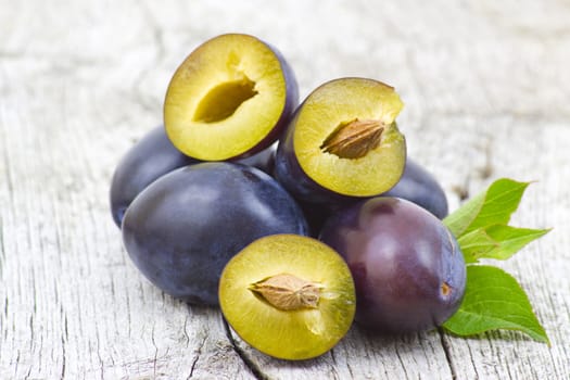 fresh plums on old wooden background