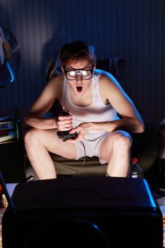 A excited teen plays video console games on His television