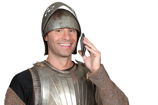 Man wearing armour holding mobile telephone