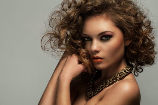 Beautiful caucasian woman with curls and evening makeup